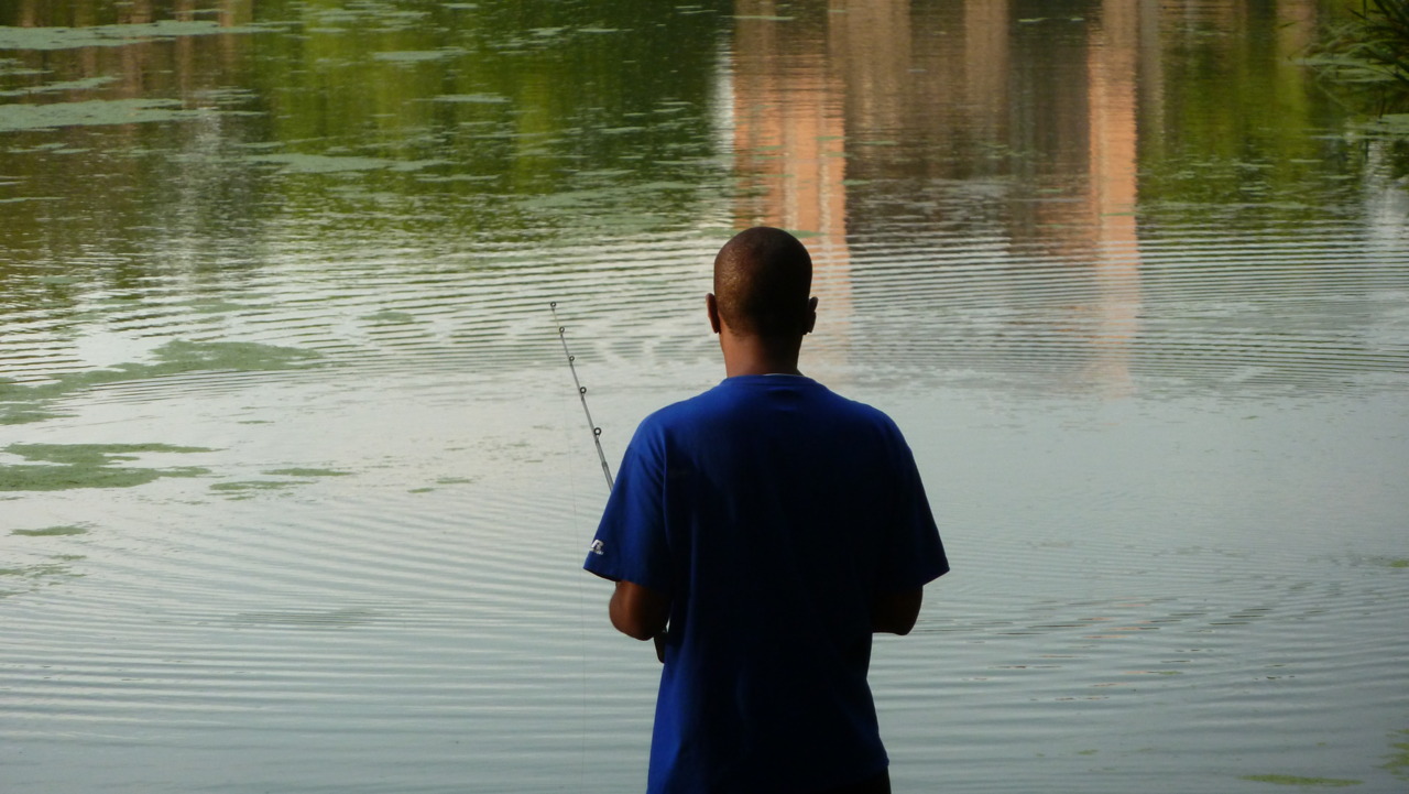 a man fishing down the street in central park